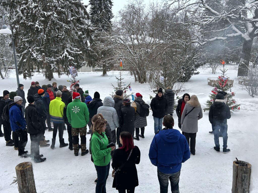 Ihmisiä seisomassa lumisella pihalla.