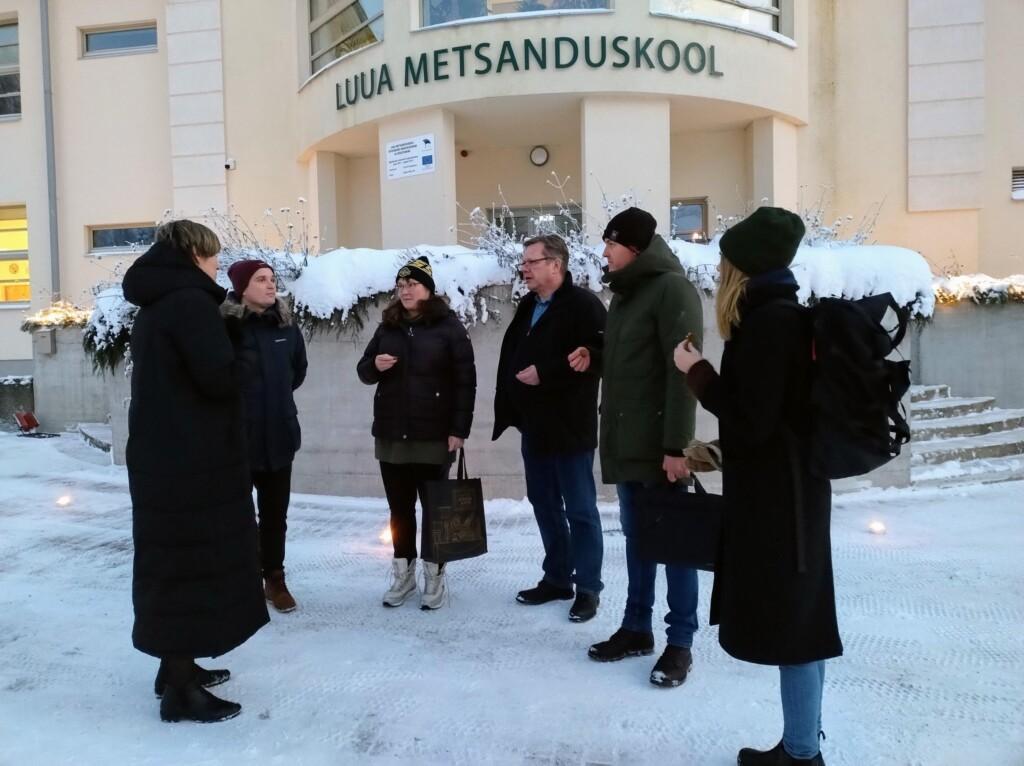 Kuusi ihmistä Viron Luua metsäoppilaitoksen oven edessä.