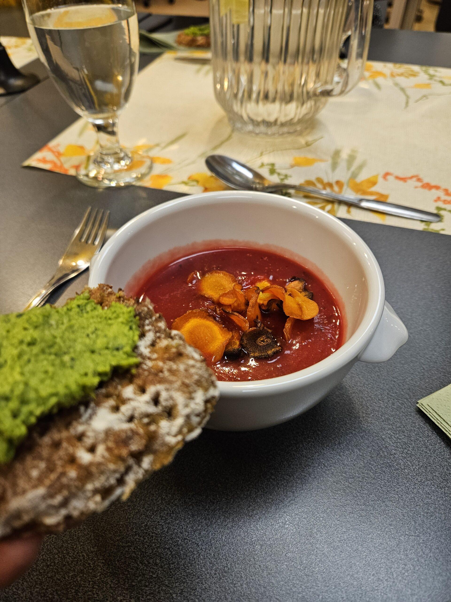 Keittolautanen pöydällä. Leipä, jodds on hummuksen tapaista päällä.