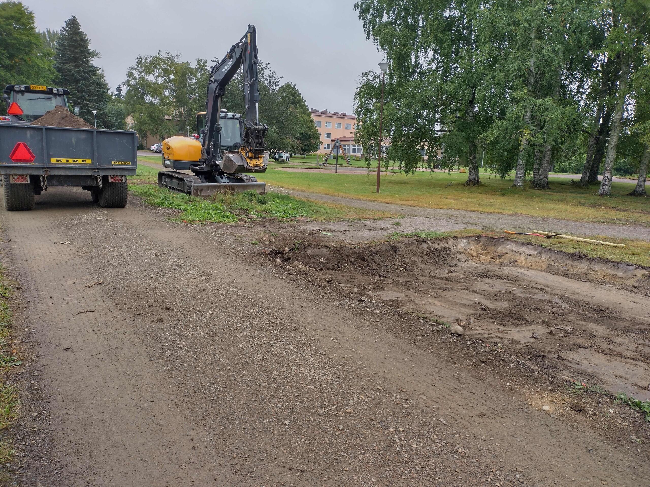 Kaivinkone poistamassa maata. Peräkärry. Kaivettua maata.