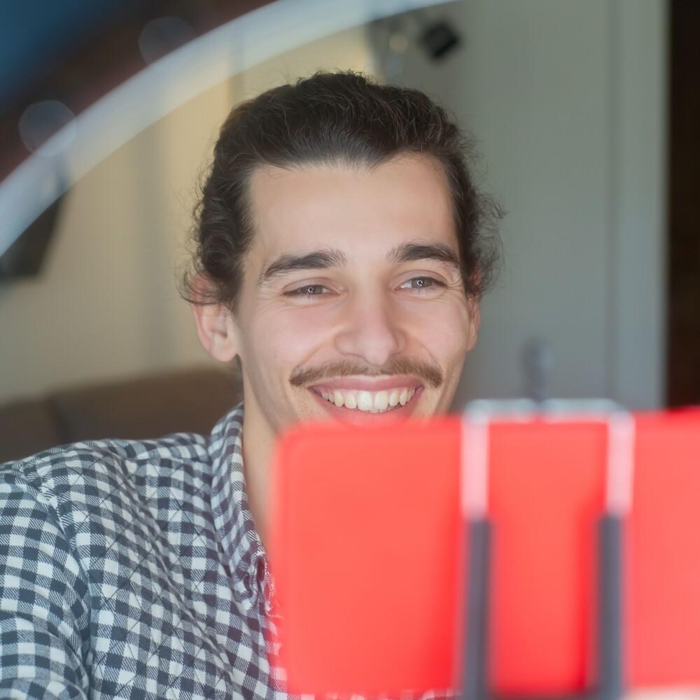 a man holding a smartphone. the man is smiling.