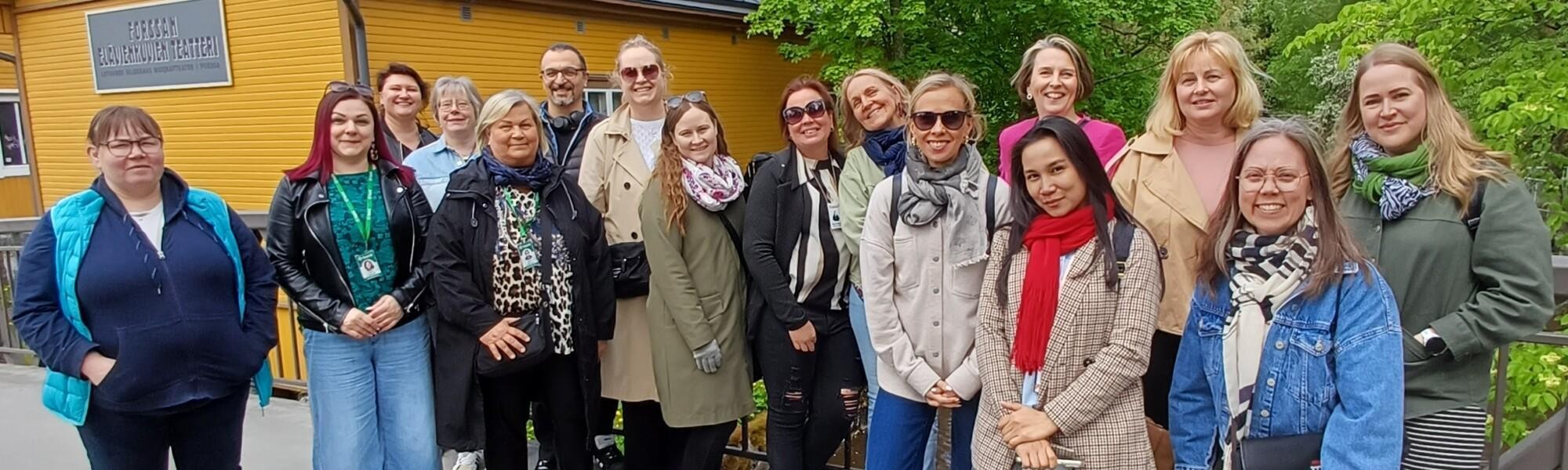 Noin 15 ihmistä Forssan saunasillalla poseeraa yhdessä kameralle