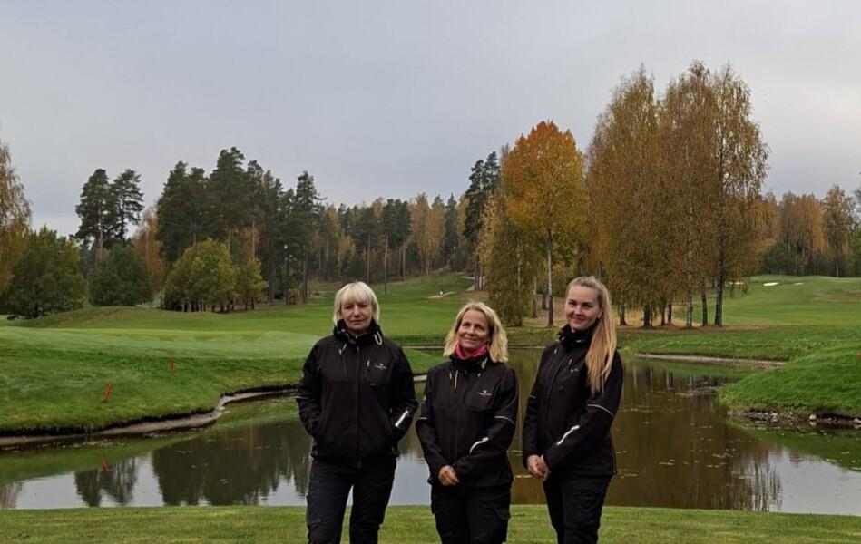 Kolme naista katsoo kameraan Vanajanlinnan Golfkentällä.